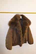 Brown fur puffer coat with a hood on a white background