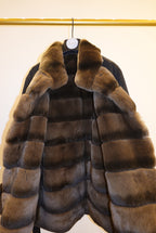 Black coat with brown fur trim against a white background