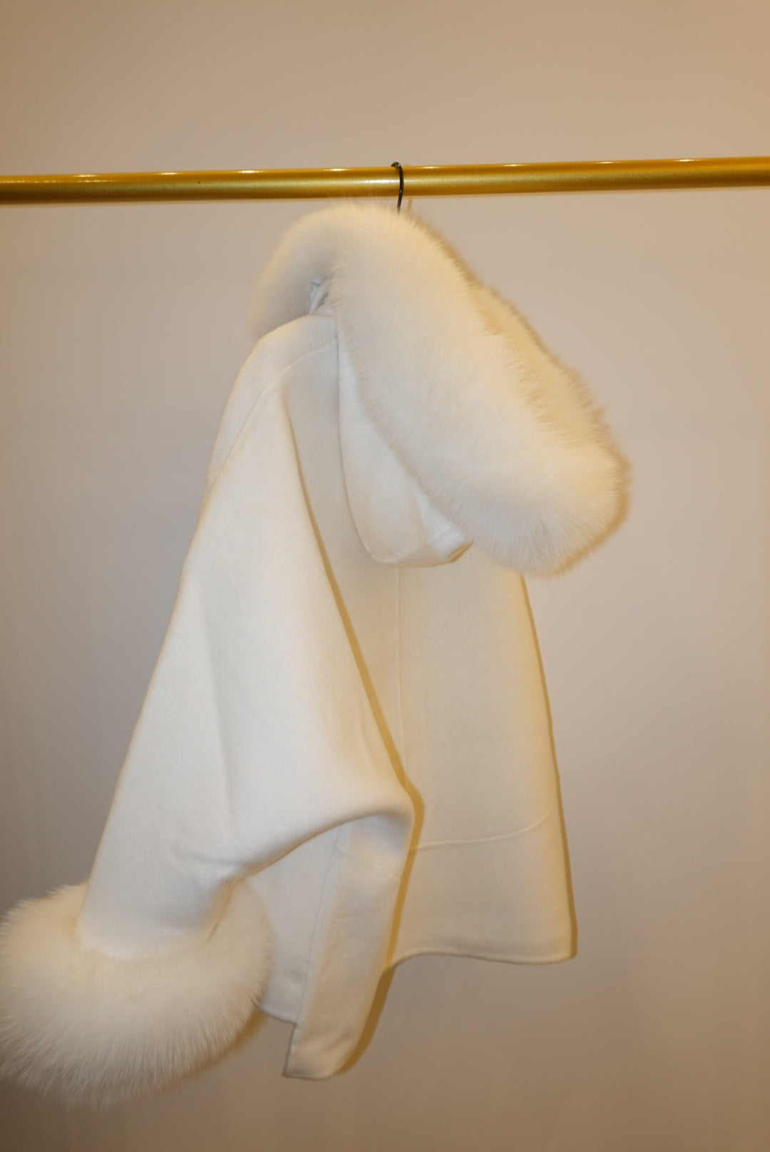 White fur coat with hood against a plain background