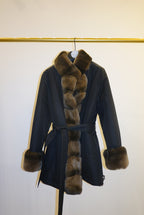 Black coat with brown fur trim against a white background
