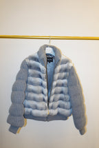 White and gray striped bomber jacket on a hanger against a white background