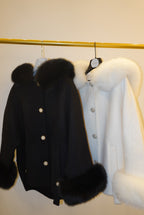 Black coat with fur trim on a white background