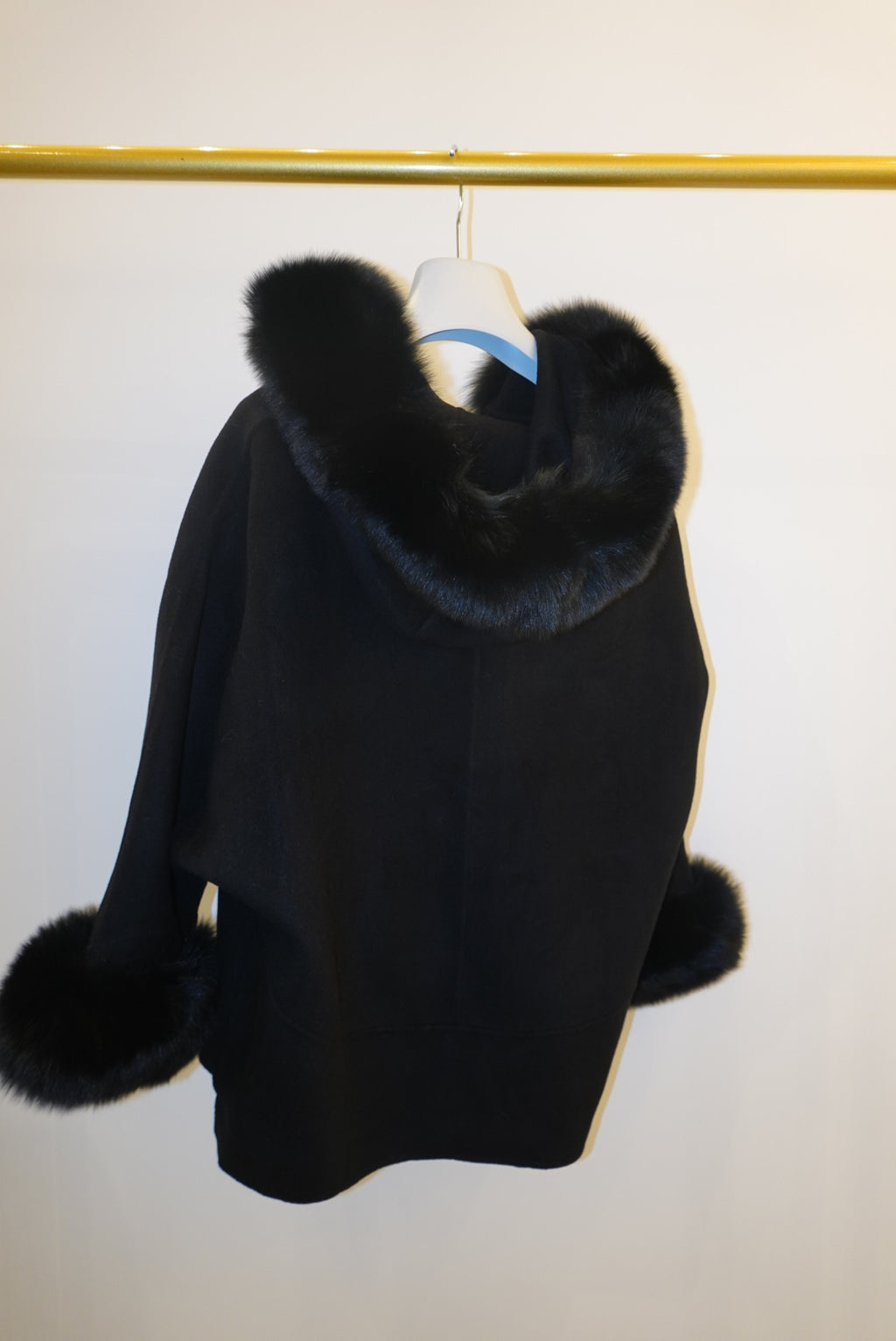 Black coat with fur trim on a white background