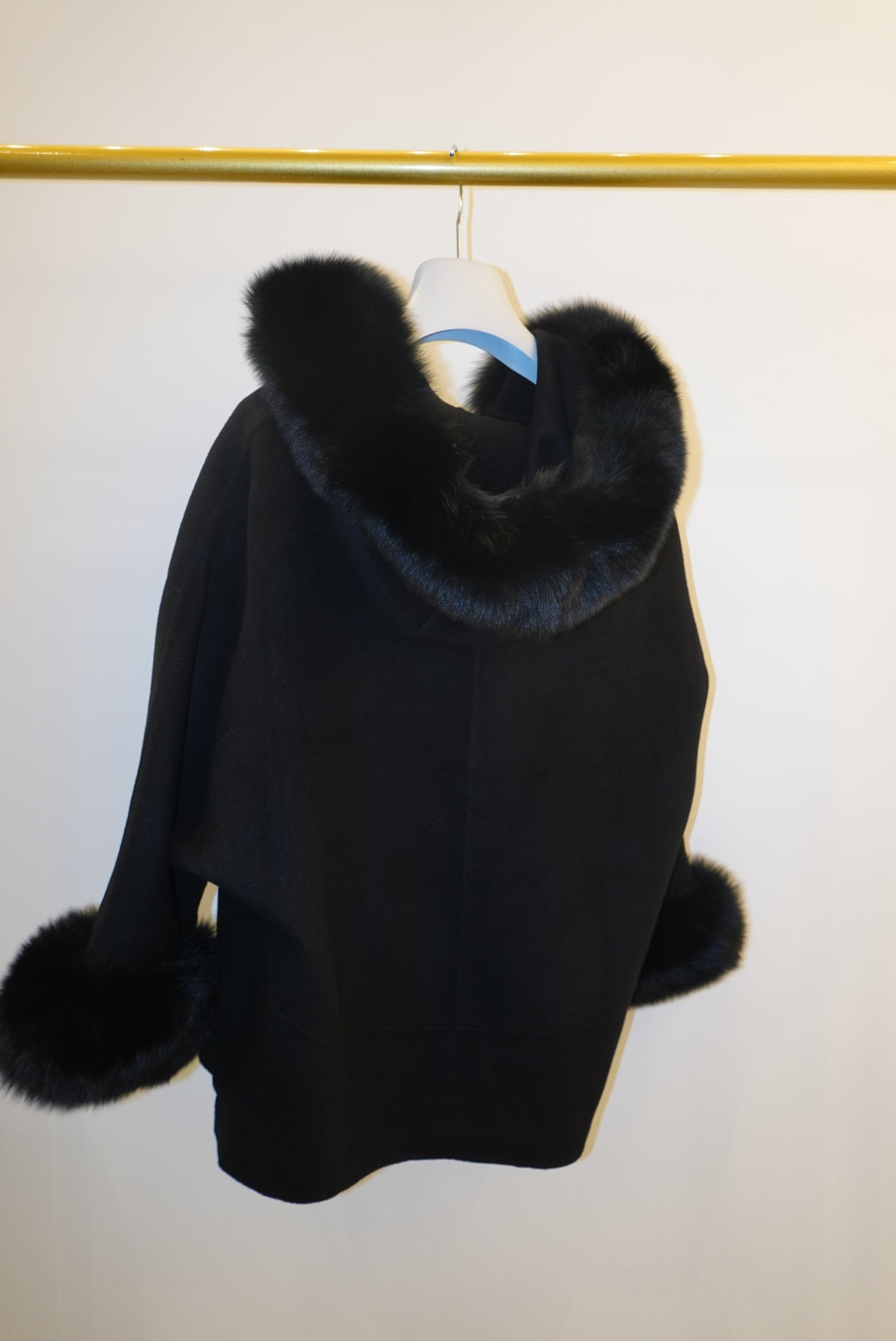 Black coat with fur trim on a white background